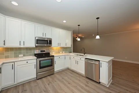 a kitchen with granite countertop white cabinets and white appliances