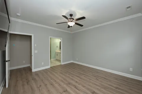 an empty room with closet and a ceiling fan