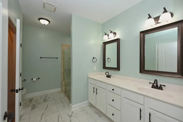 a bathroom with a double vanity sink and a mirror