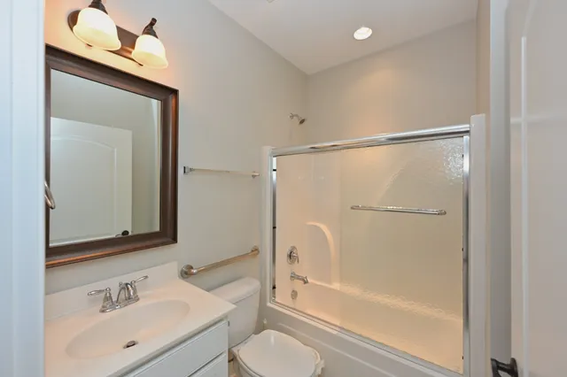 a bathroom with a bathtub shower sink vanity and toilet