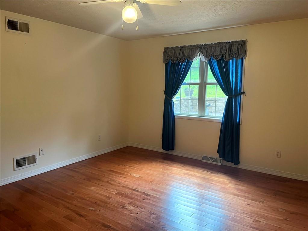 75 Cave Street Fairchance, PA 15436 - Photo 12 of 36 an empty room with wooden floor and windows