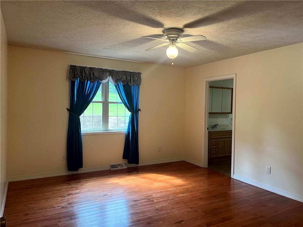 75 Cave Street Fairchance, PA 15436 - Photo 14 of 36 an empty room with wooden floor and windows