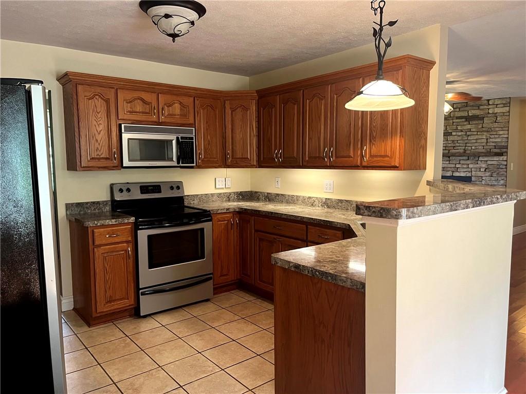 75 Cave Street Fairchance, PA 15436 - Photo 8 of 36 a kitchen with stainless steel appliances granite countertop a stove microwave and sink