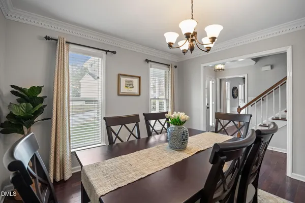 a view of a dining room with furniture a chandelier and wooden floor