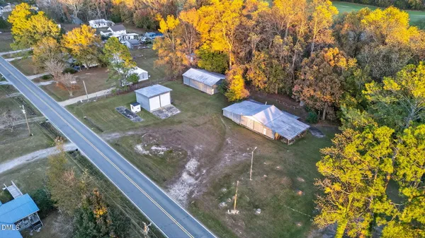 a view of a house with a yard and a large tree