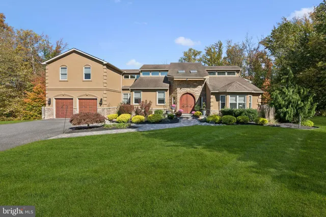 a view of a big house with a big yard and large trees