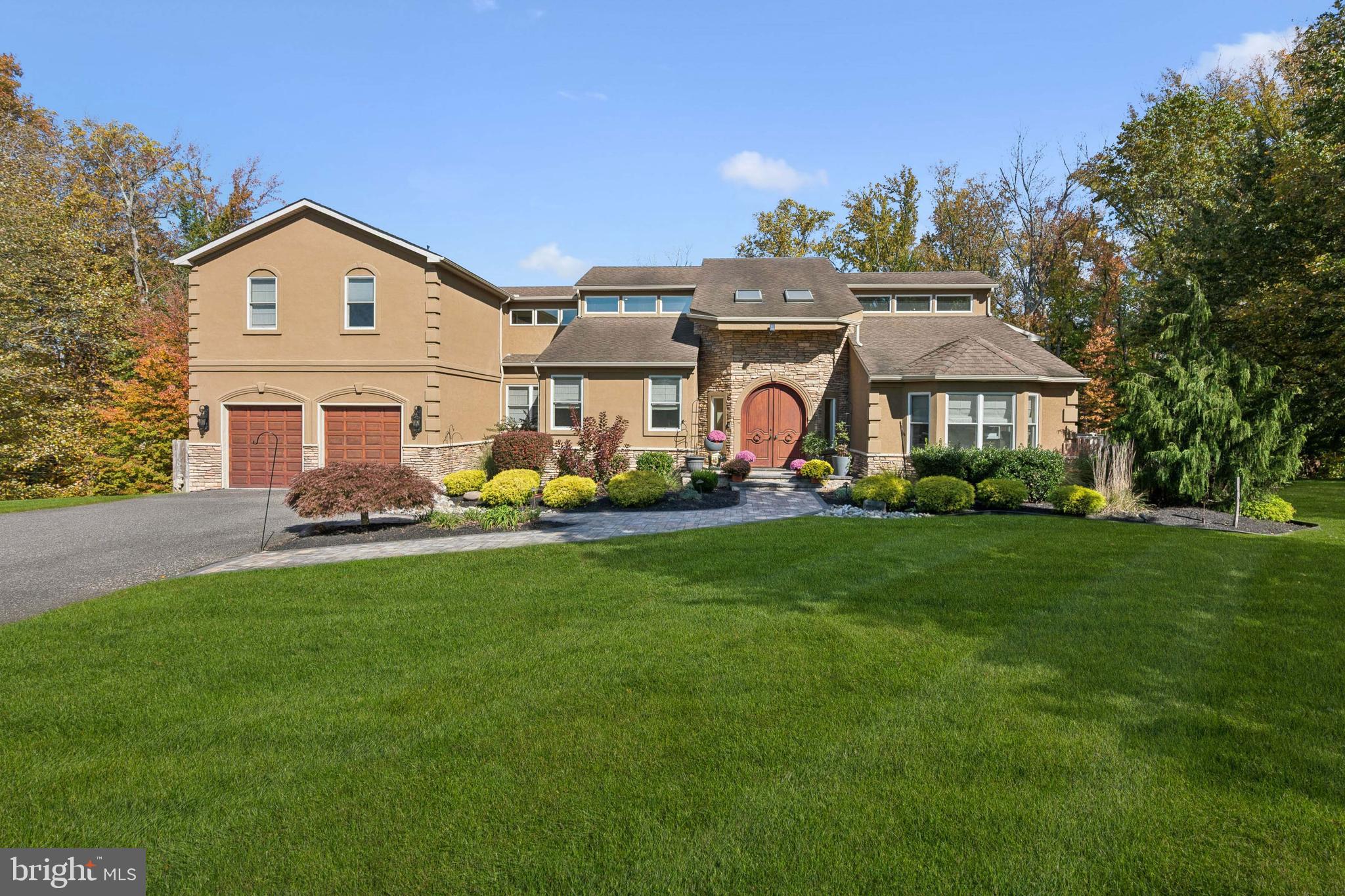 a view of a big house with a big yard and large trees