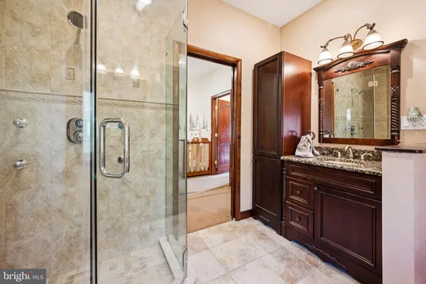 a spacious bathroom with a granite countertop sink mirror and shower