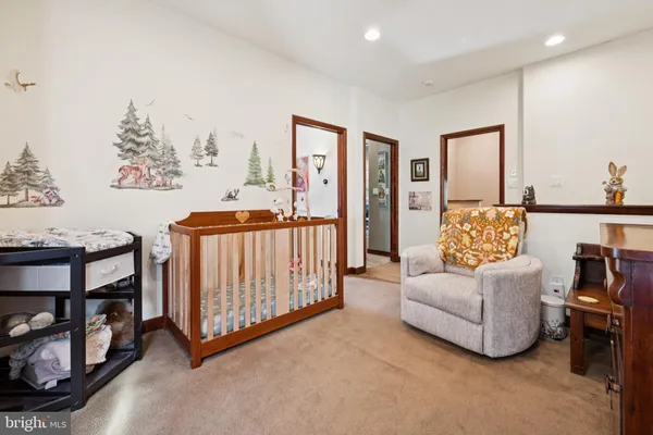 a living room with furniture and a baby crib