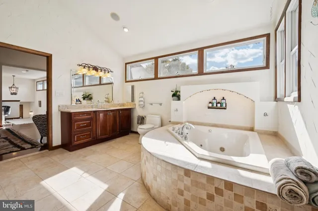 a bathroom with a tub sink and mirror
