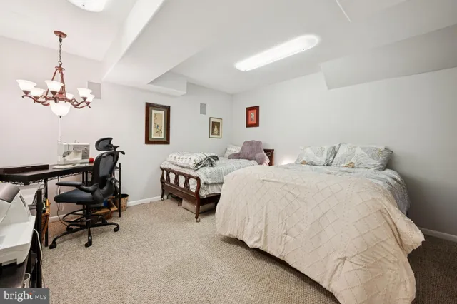 a bedroom with bed and a chandelier