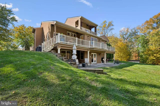 a view of a house with a big yard and large trees
