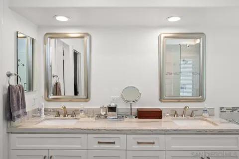 a bathroom with double vanity sinks and a mirror