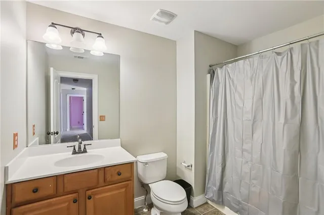 a bathroom with a granite countertop sink a toilet and a mirror