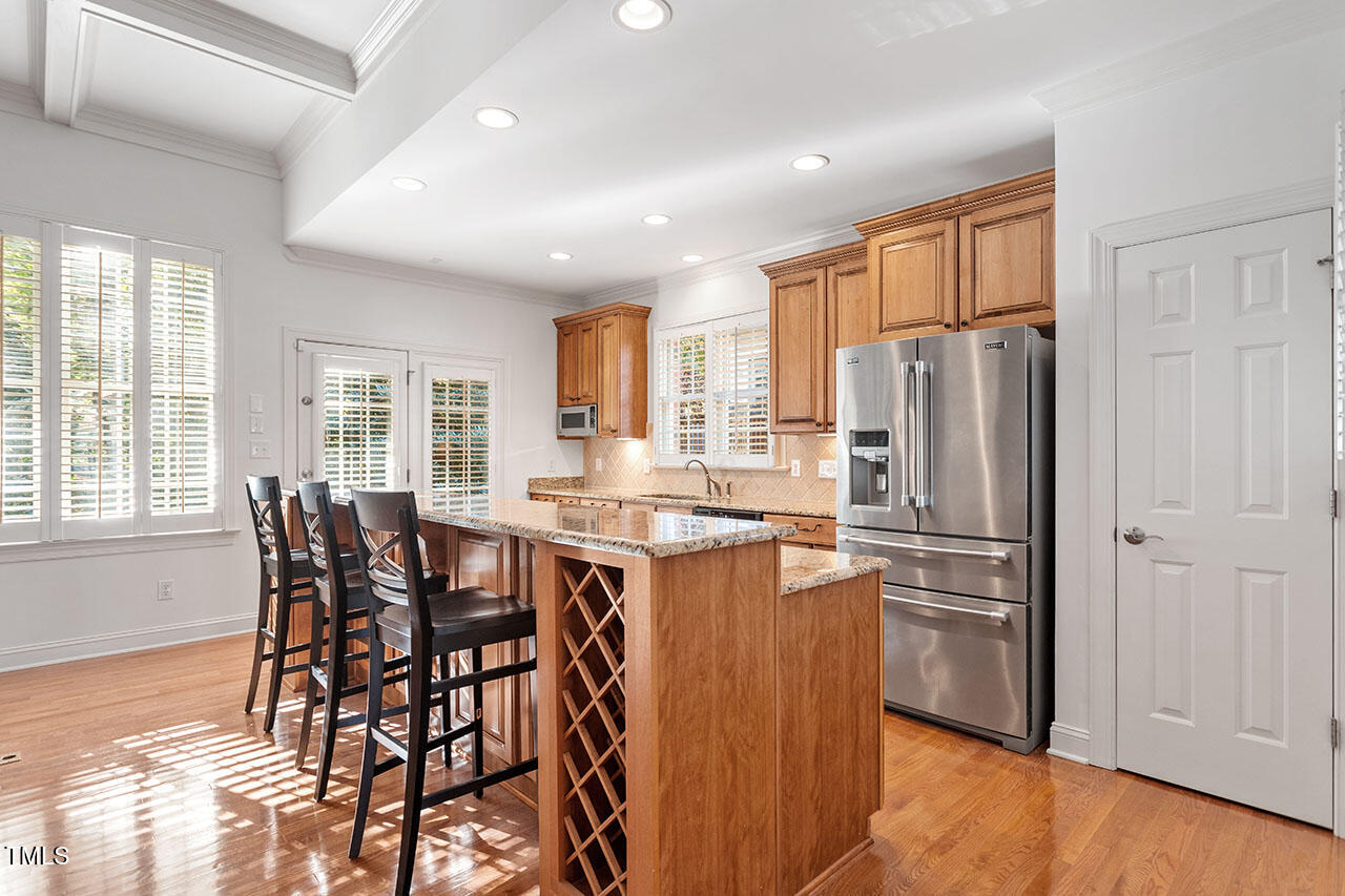 7342 Fontana Ridge Lane Raleigh, NC 27613 - Photo 7 of 26 a kitchen with stainless steel appliances a dining table chairs refrigerator and cabinets