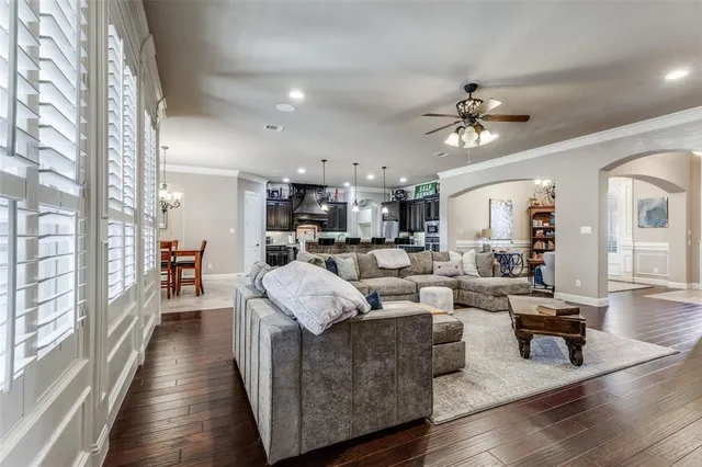 a living room with furniture kitchen view and a large window