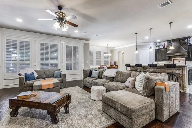 a living room with furniture a large window and a chandelier