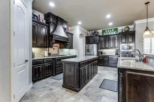 a kitchen with granite countertop a sink and a refrigerator