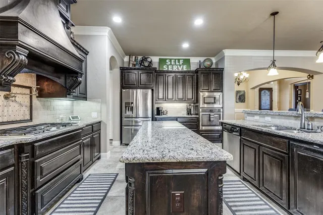 a kitchen with stainless steel appliances granite countertop a stove and a sink
