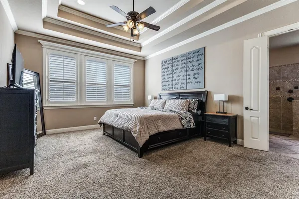 a spacious bedroom with a bed dresser and a window