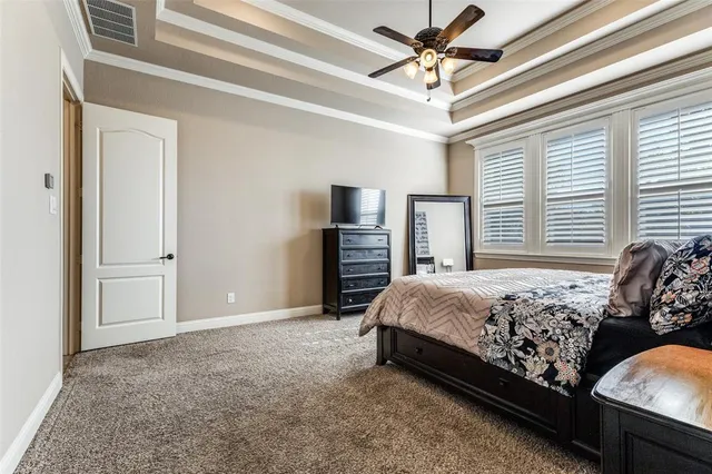 a bed sitting in a spacious bedroom next to a window