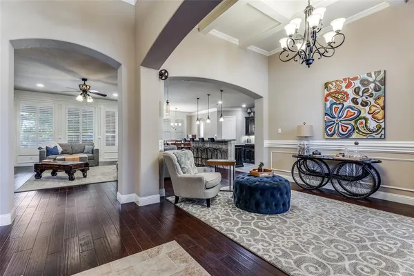 a living room with furniture a dining table and paintings on the wall