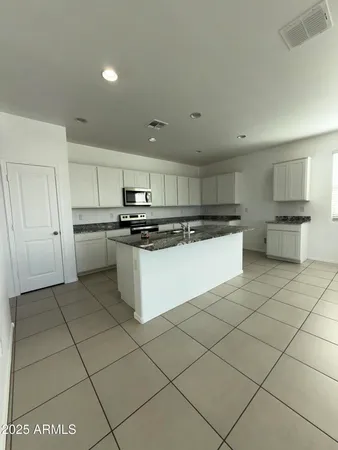 a kitchen with granite countertop a sink a stove and cabinets