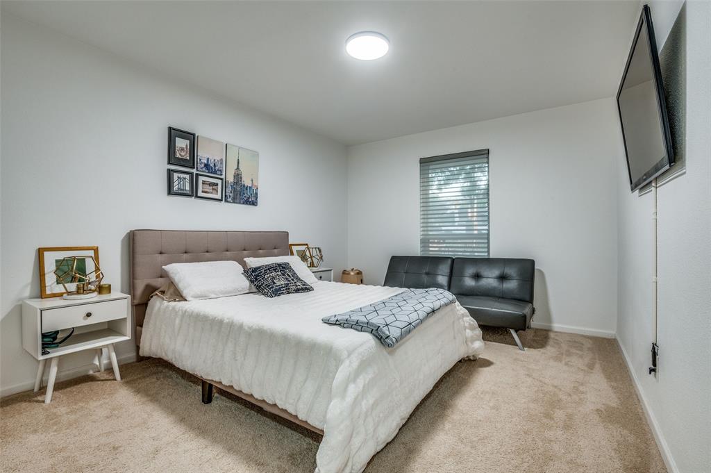 11211 McCree Road Dallas, TX 75238 - Photo 16 of 29 a bedroom with a bed a couch and a flat tv screen on a dresser