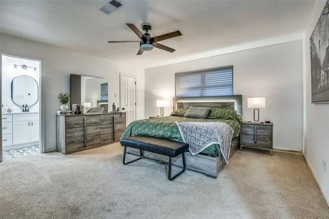 a bedroom with a bed a chandelier and dresser
