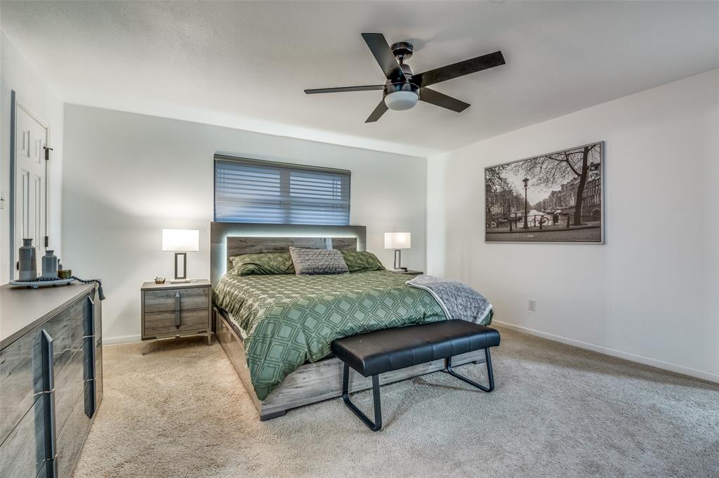 11211 McCree Road Dallas, TX 75238 - Photo 18 of 29 a bedroom with a bed and a chandelier