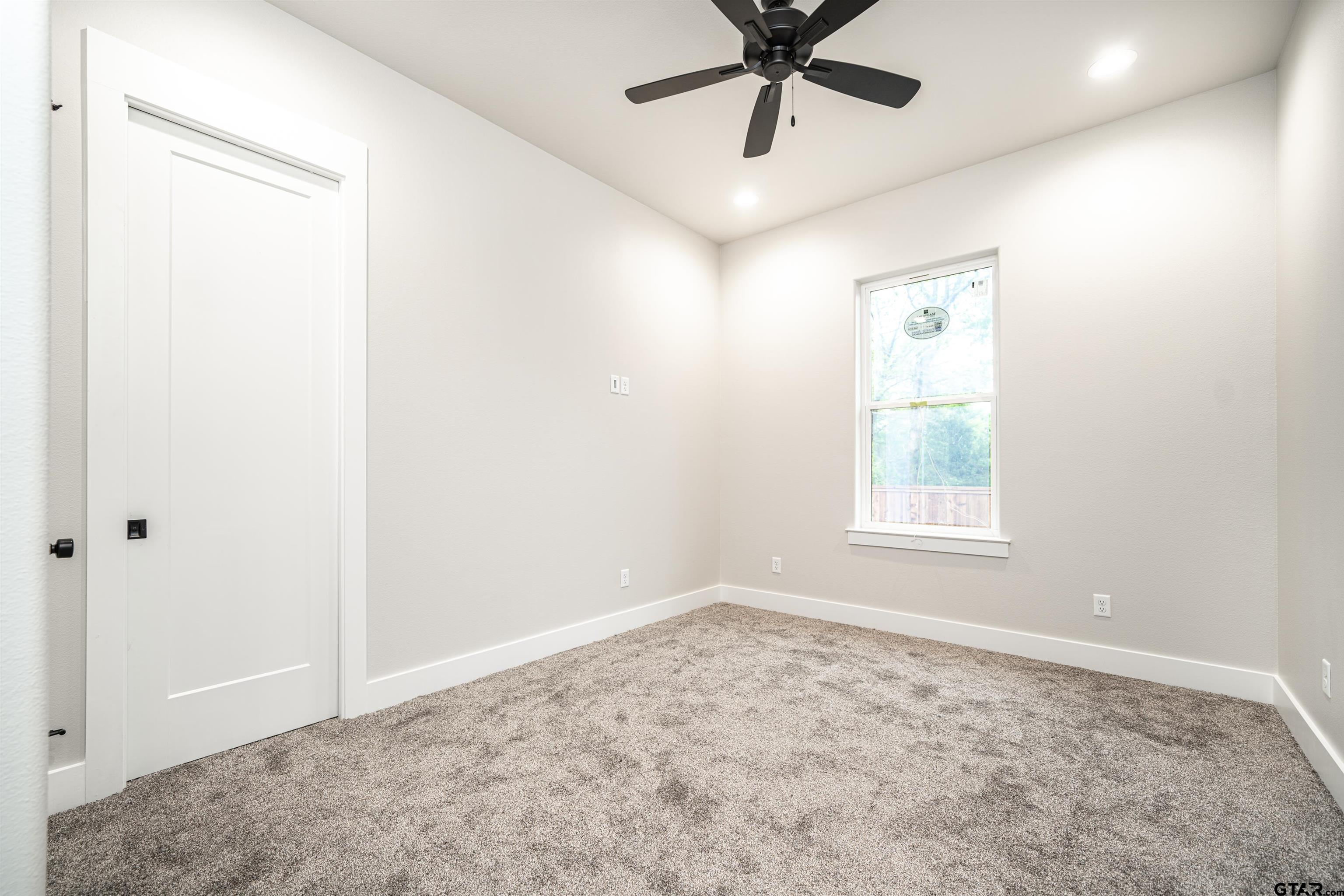 3910 Hidden Hills Circle Longview, TX 75605 - Photo 24 of 39 an empty room with a window and a fan