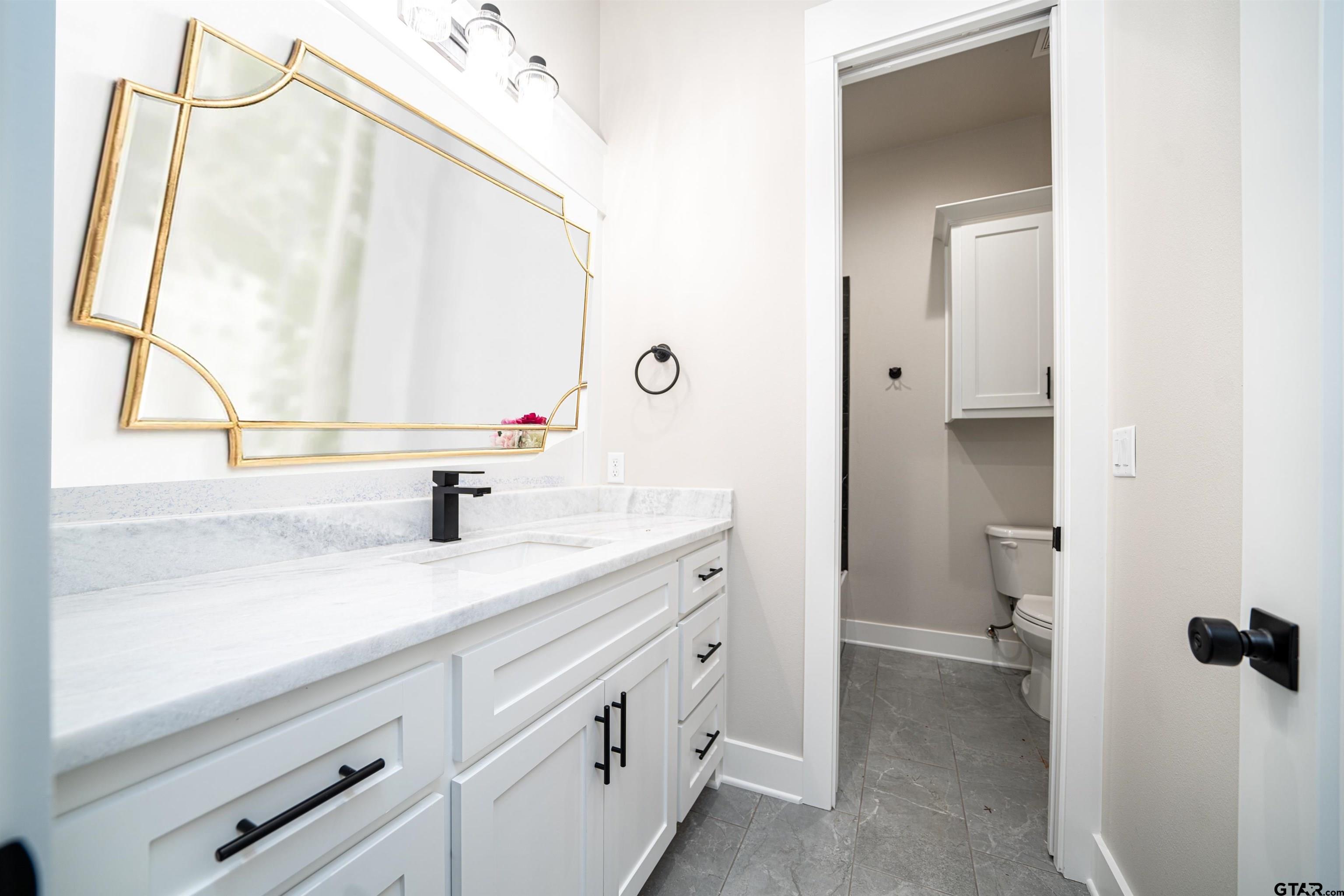 3910 Hidden Hills Circle Longview, TX 75605 - Photo 25 of 39 a bathroom with a sink and a mirror with toilet