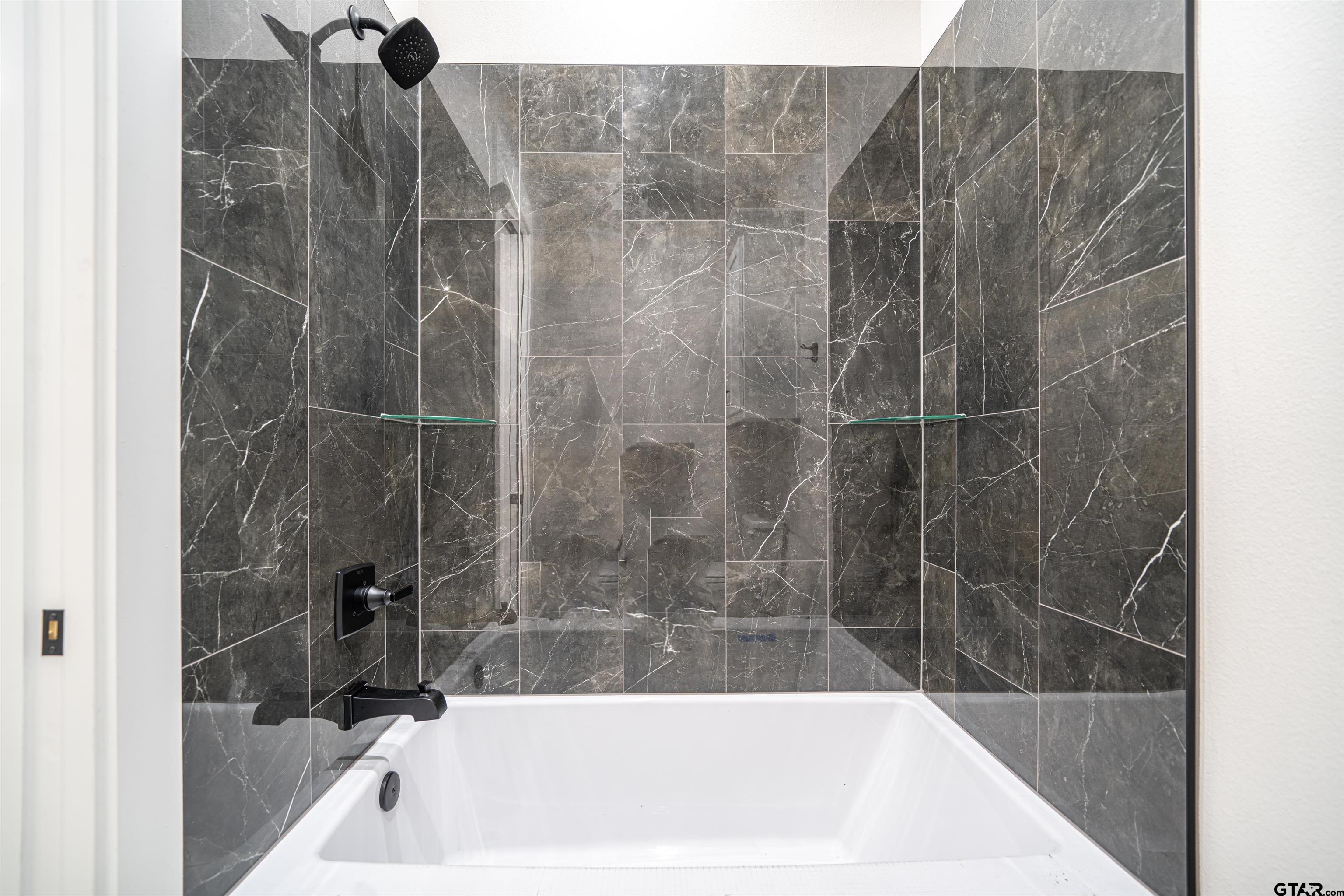 3910 Hidden Hills Circle Longview, TX 75605 - Photo 26 of 39 a bathroom with a bathtub and a shower