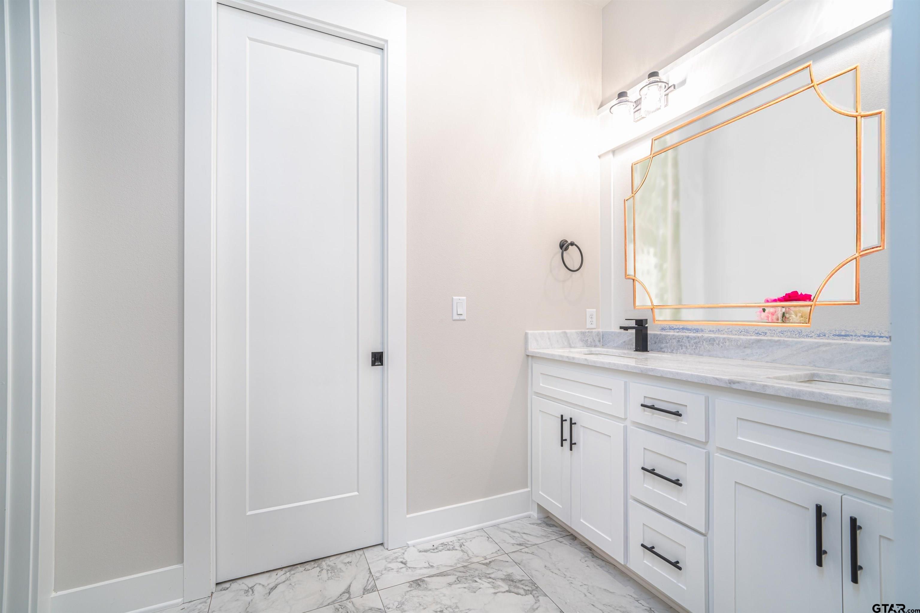 3910 Hidden Hills Circle Longview, TX 75605 - Photo 28 of 39 a bathroom with a double vanity sink and a mirror