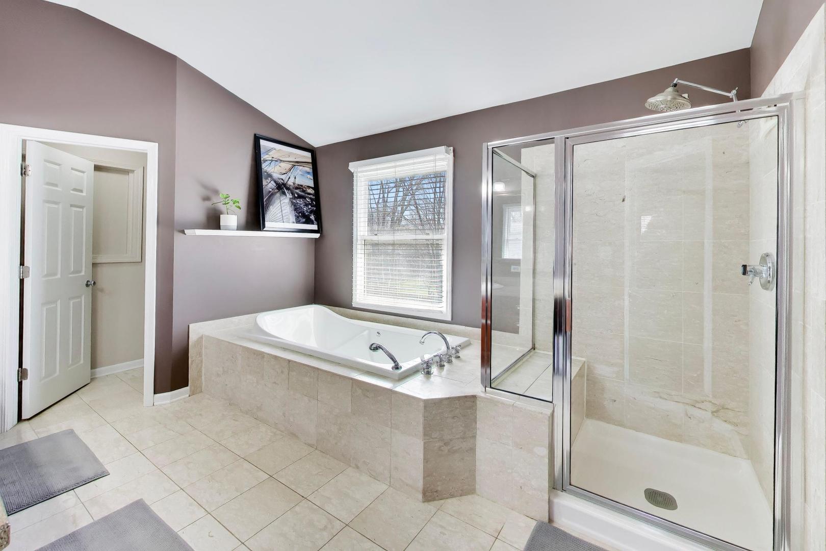 44 Swift Lane Naperville, IL 60565 - Photo 28 of 37 a bathroom with a tub a sink and a window