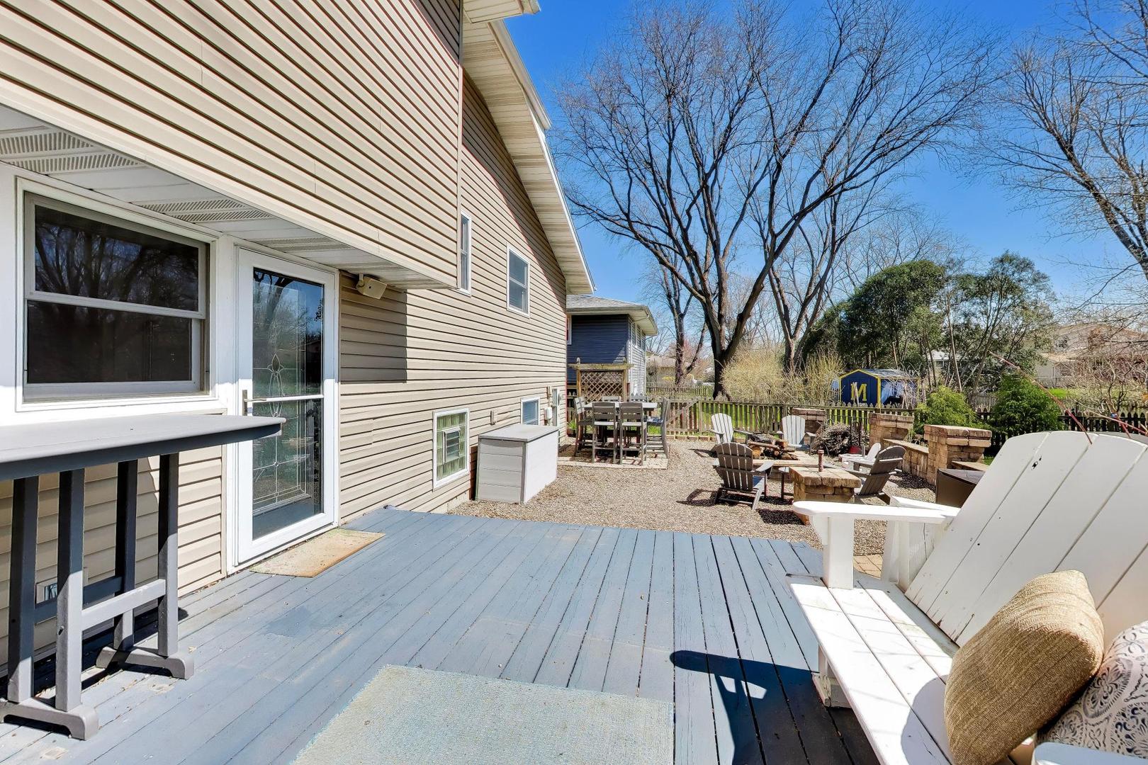 44 Swift Lane Naperville, IL 60565 - Photo 32 of 37 a view of a patio with couches table and chairs with wooden floor and fence