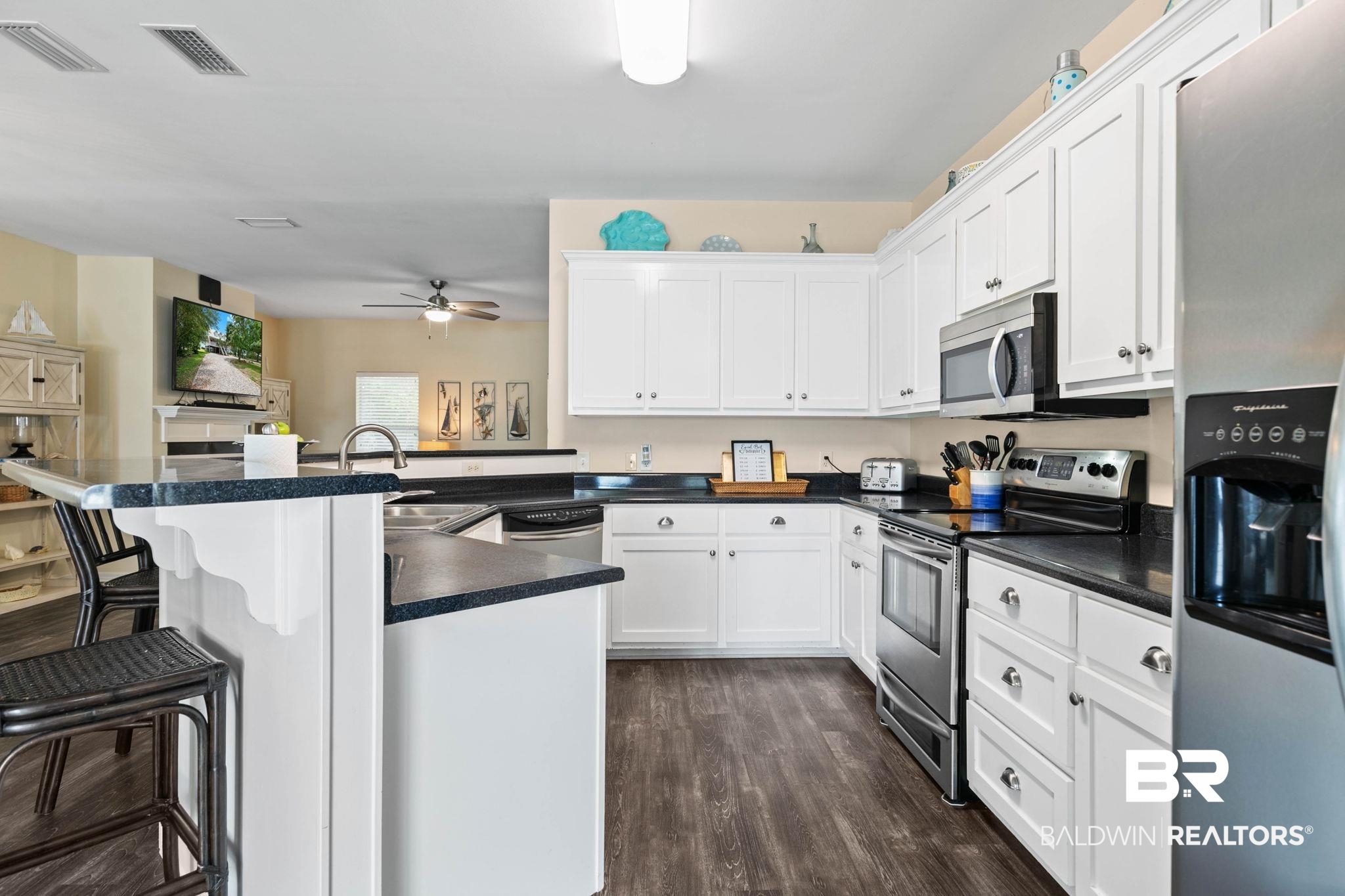 6802 Shore Drive Elberta, AL 36530 - Photo 12 of 34 Kitchen featuring white cabinetry with brushed nickel hardware, dark speckled countertops, and wood-finish flooring