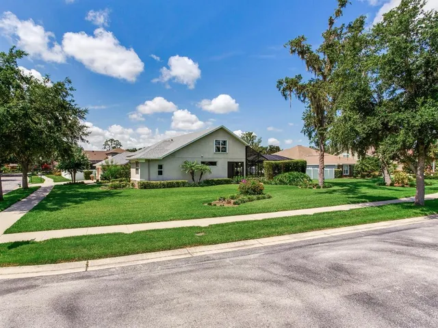 a front view of a house with a yard and trees