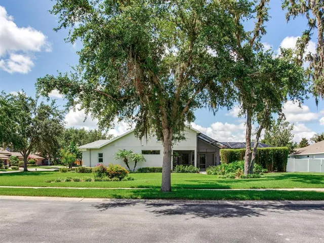 a view of a house with a big yard and potted plants