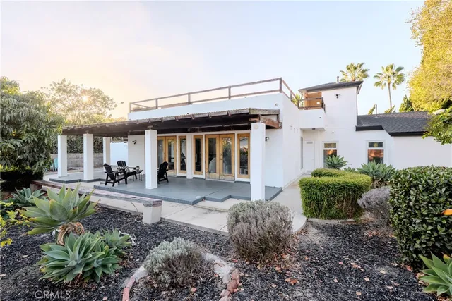 a front view of a house with sitting area and garden