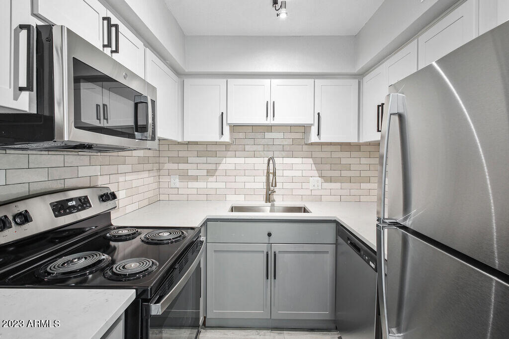 10002 North 7th Street, Unit B1 Phoenix, AZ 85020 - Photo 3 of 11 a kitchen with a sink stove and refrigerator