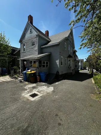 a front view of a house with cars parked on road