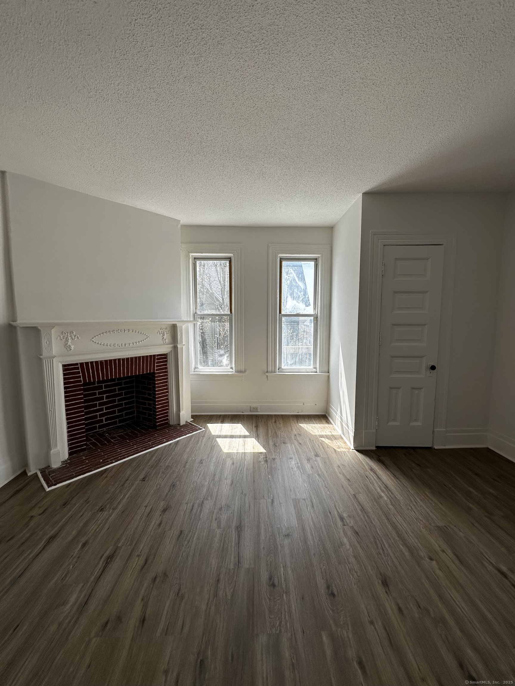 50 Chestnut Avenue Waterbury, CT 06710 - Photo 22 of 30 an empty room with wooden floor fireplace and windows