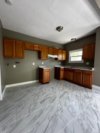 a large kitchen with stainless steel appliances granite countertop a sink and cabinets