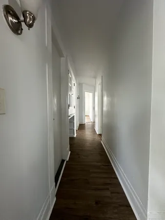a view of a hallway with wooden floor and staircase