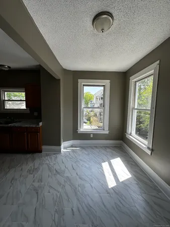 an empty room with windows and chandelier