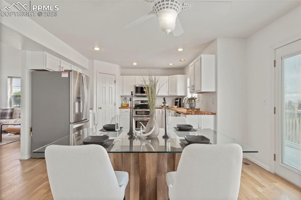 11916 Bonifay Loop Peyton, CO 80831 - Photo 12 of 42 a view of kitchen with stainless steel appliances refrigerator dining table and chairs