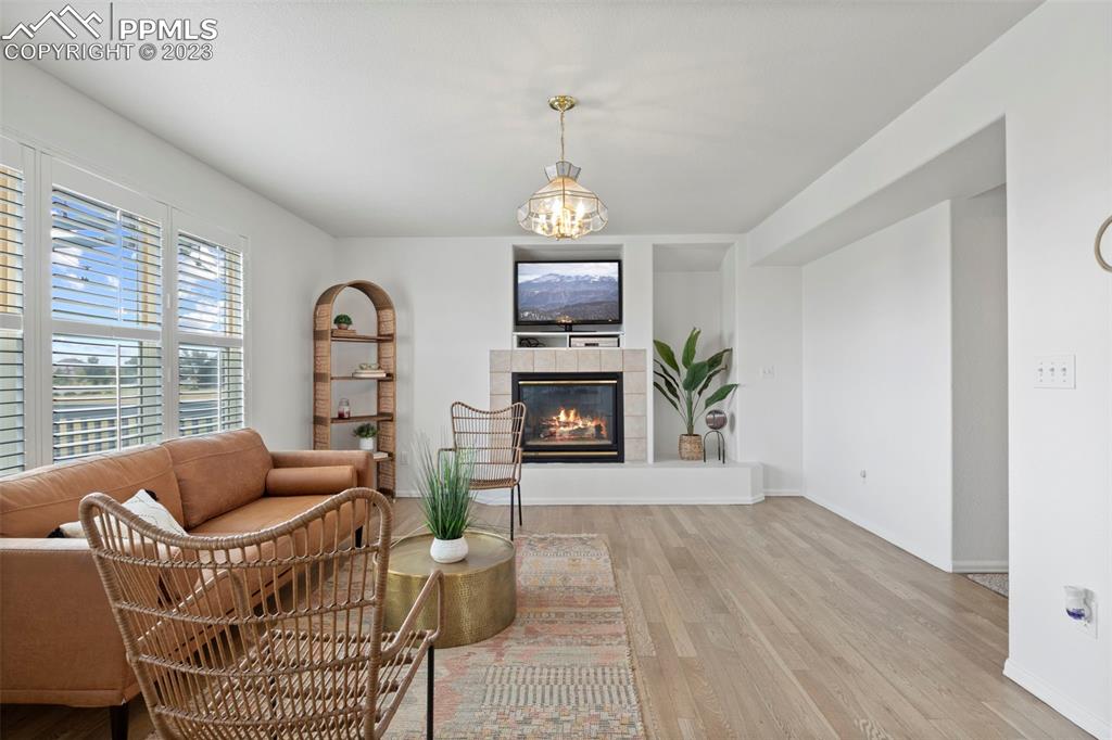 11916 Bonifay Loop Peyton, CO 80831 - Photo 15 of 42 a living room with furniture a fireplace and a chandelier