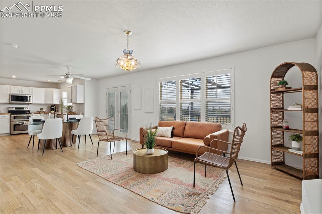 11916 Bonifay Loop Peyton, CO 80831 - Photo 16 of 42 a living room with furniture a rug kitchen view and a large window