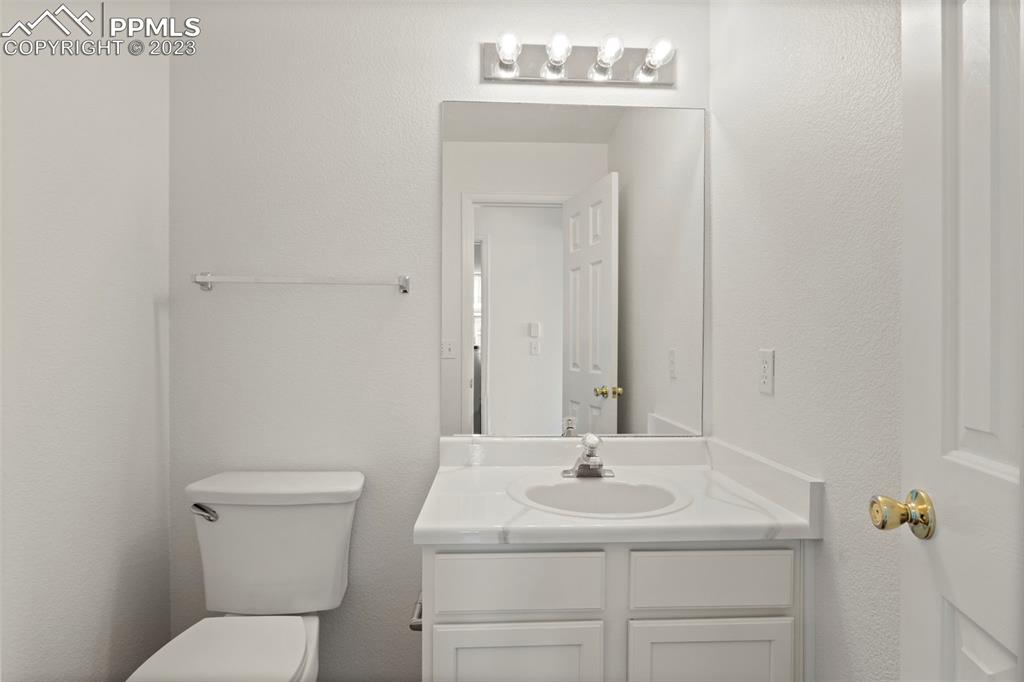 11916 Bonifay Loop Peyton, CO 80831 - Photo 17 of 42 a bathroom with a toilet sink and mirror